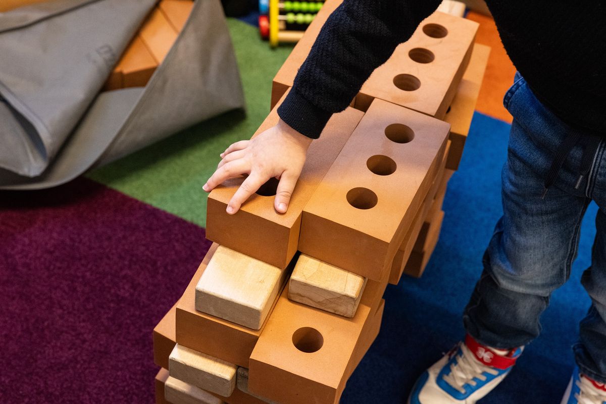 Child's hand building wall with bricks