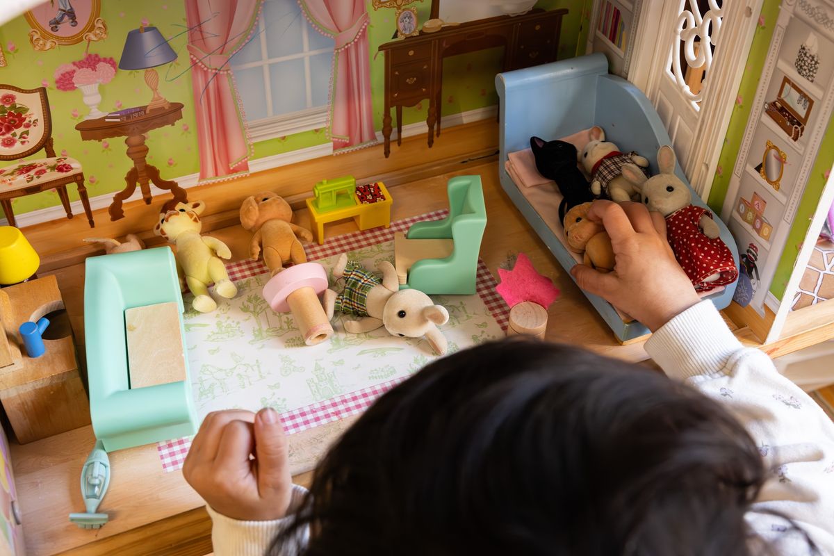 Girl playing with animals in doll's house