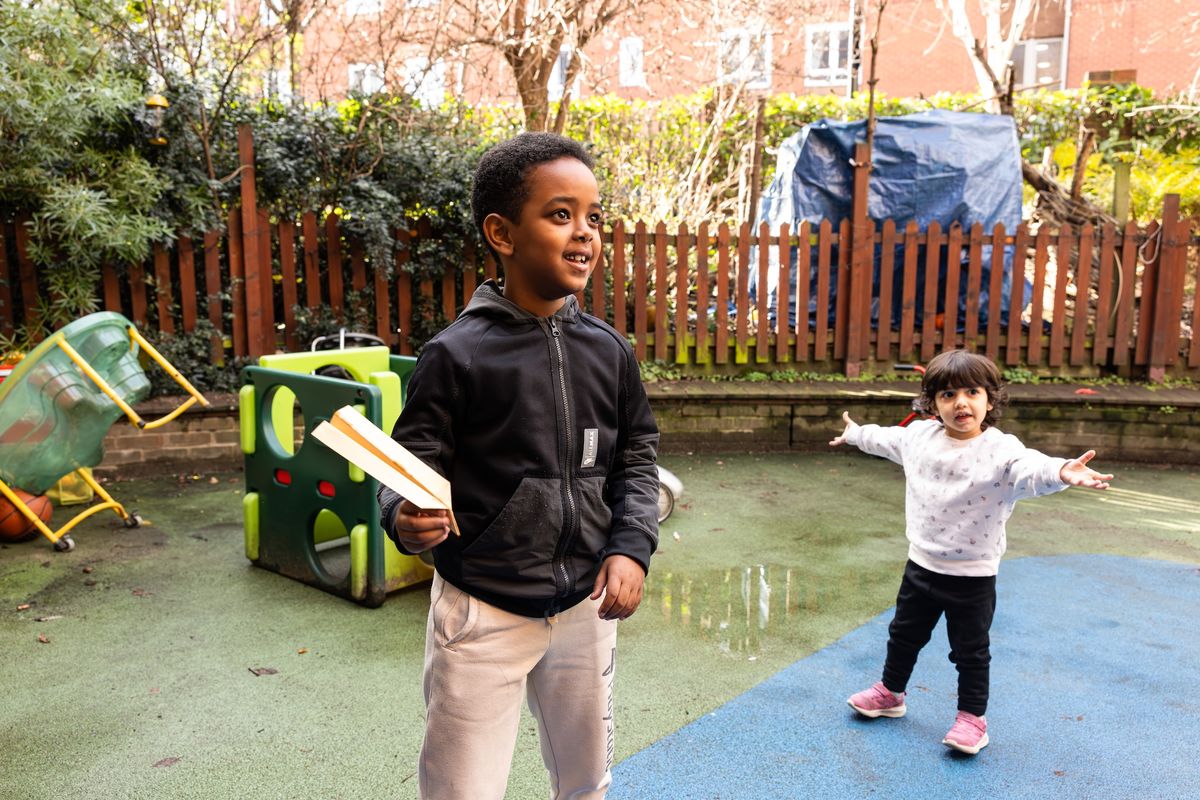 Boy playing with paper aeroplane