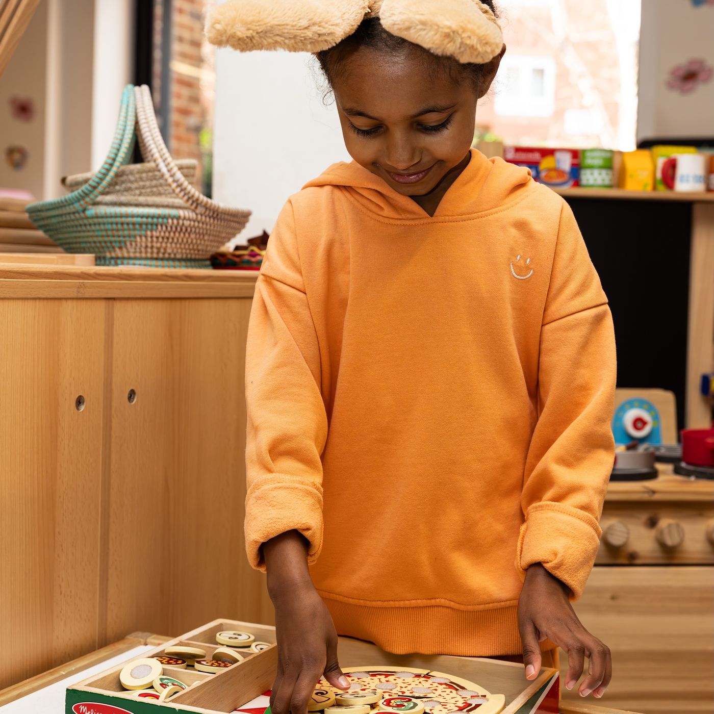 Small girl playing with toy pizza